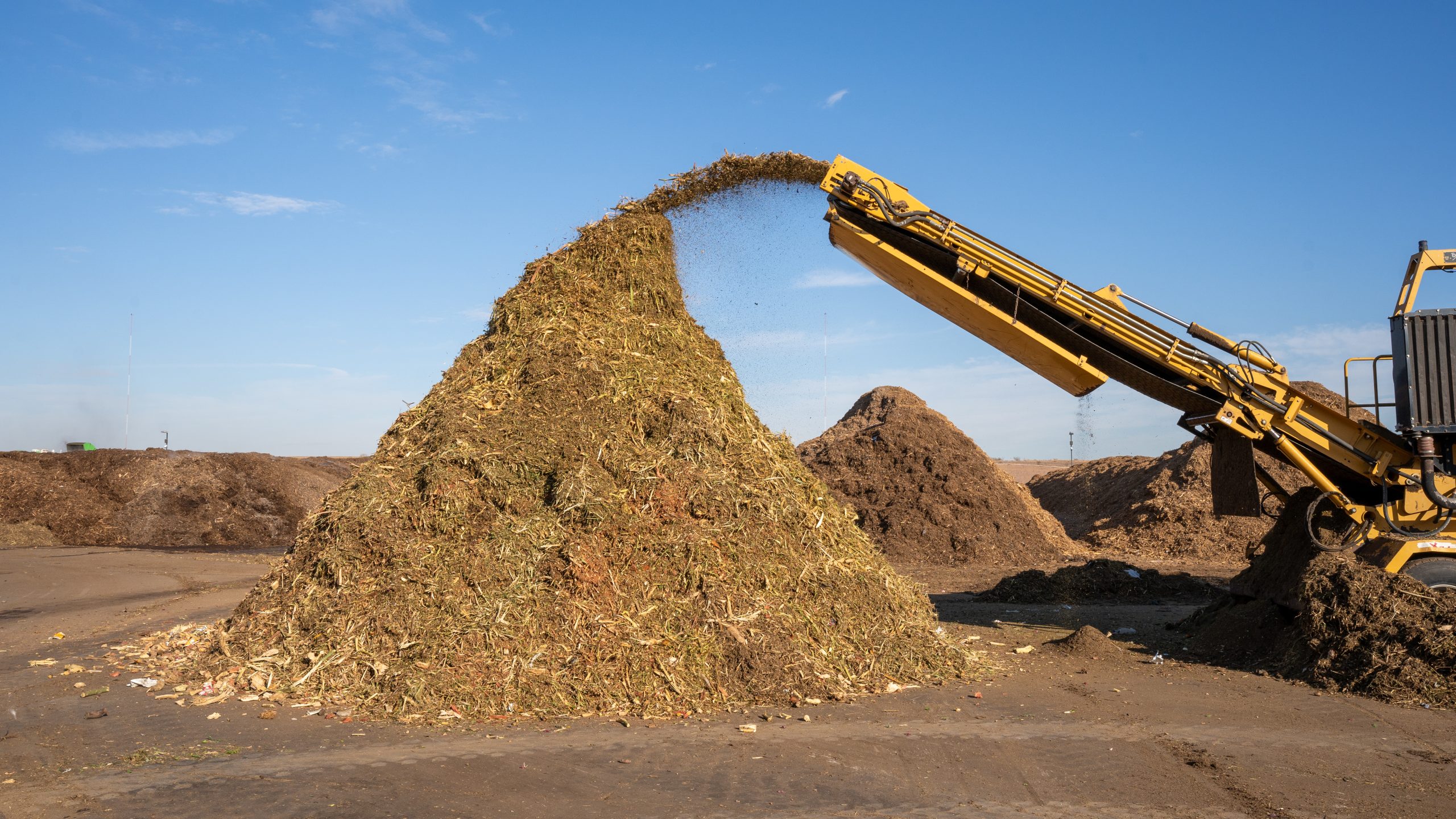 A machine mixes green waste and depackaged food waste to start the composting process.