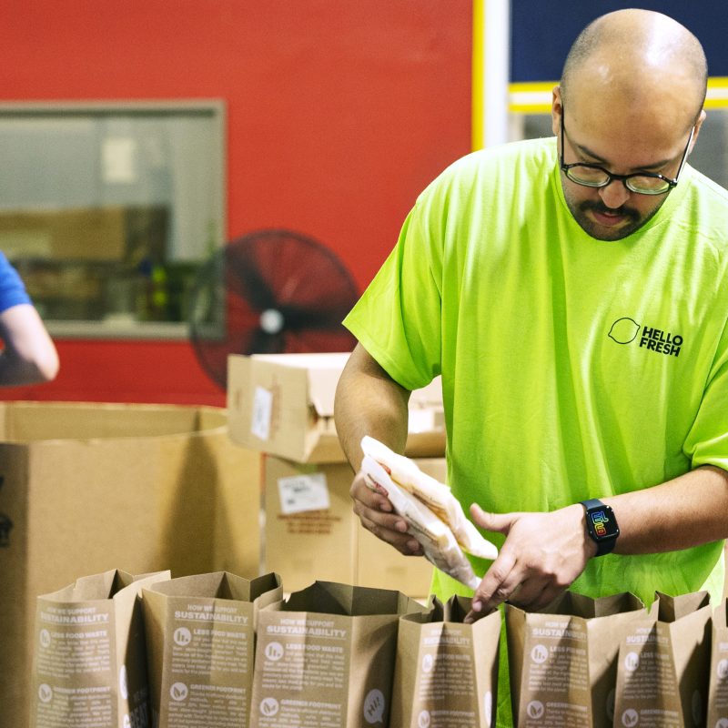 A HelloFresh team member packs donation bags, helping to provide nutritious meals to those in need.