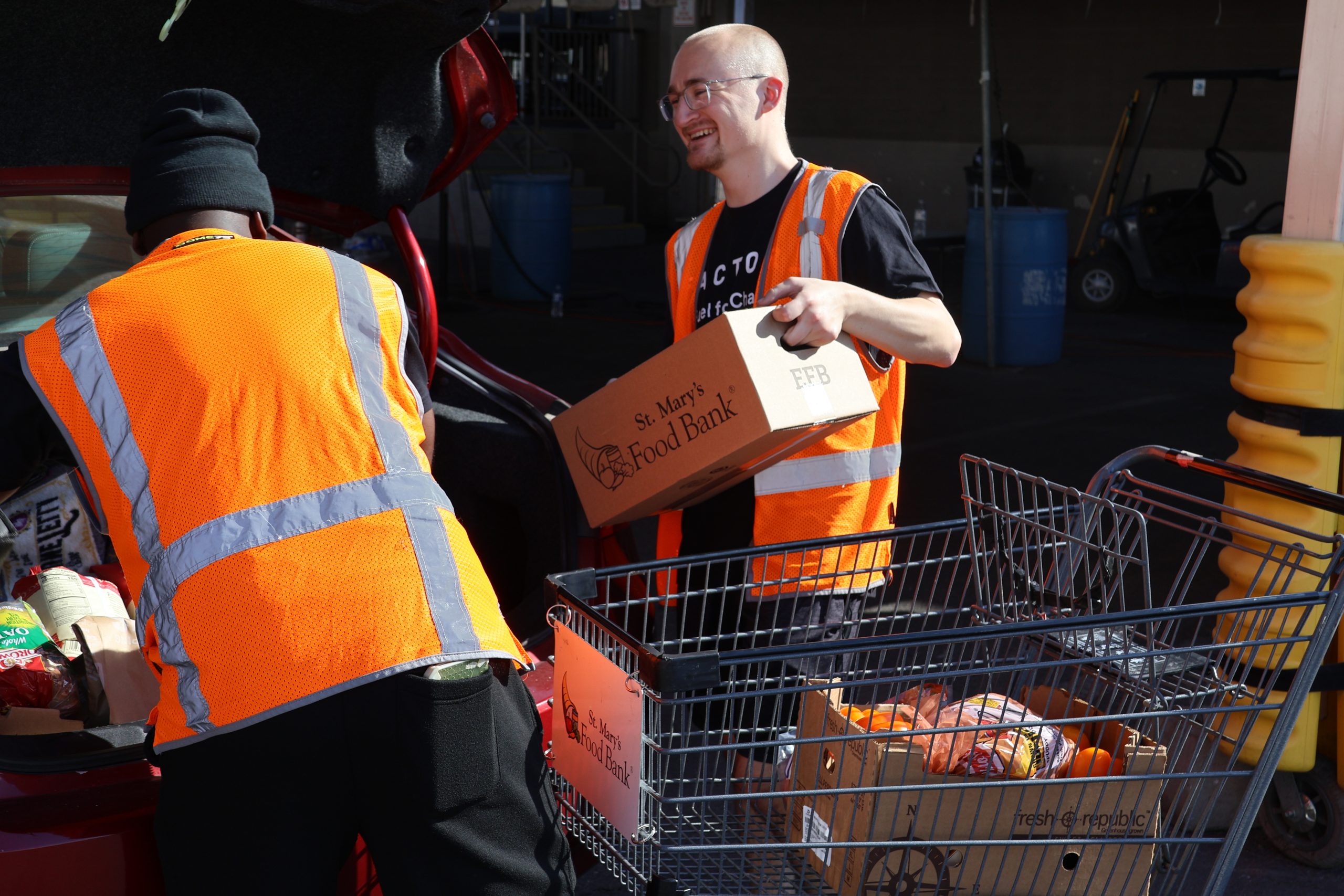 A teammate happily packs donated food for St. Mary's Food Bank.