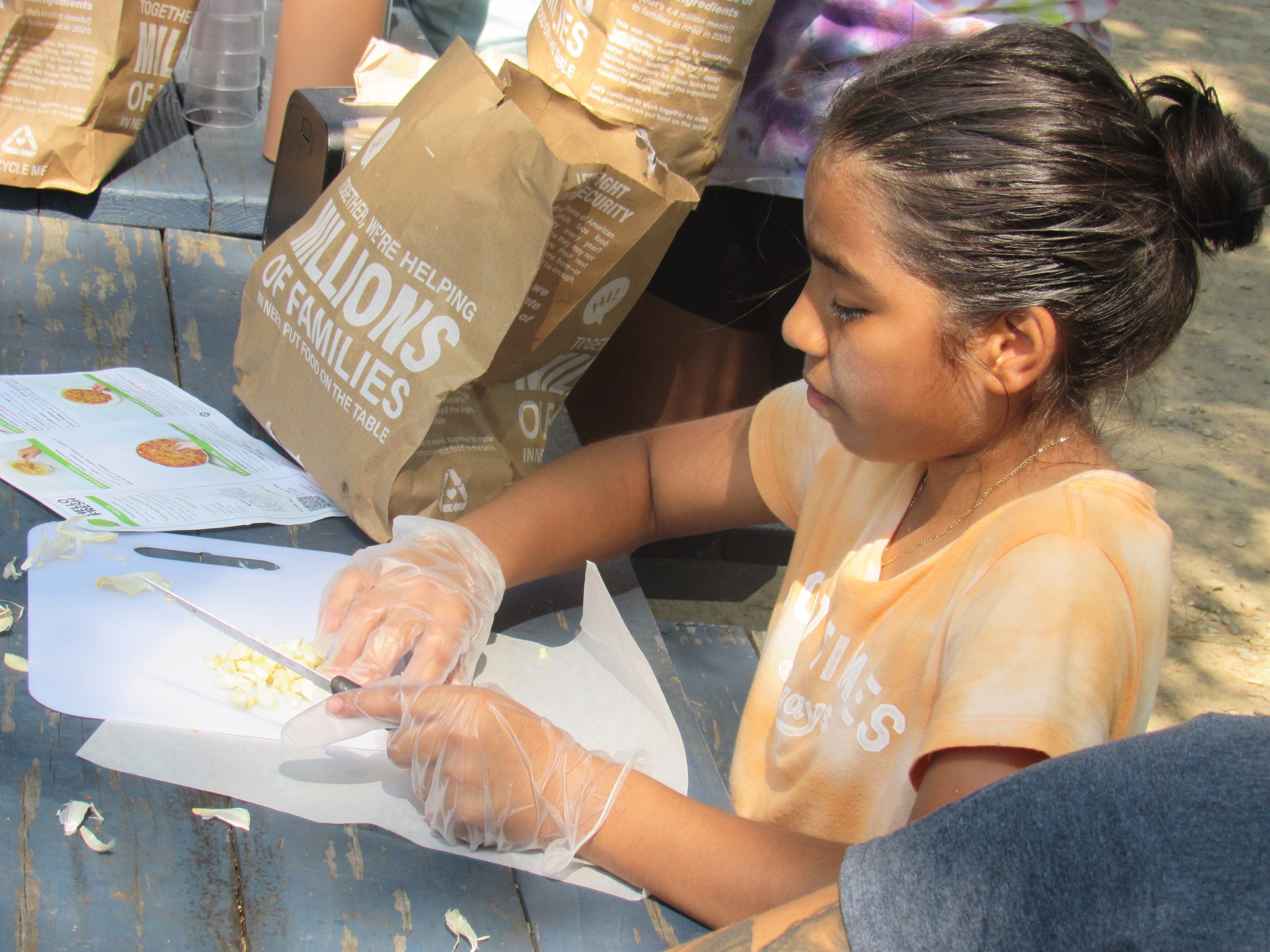 girl chops food at summer program