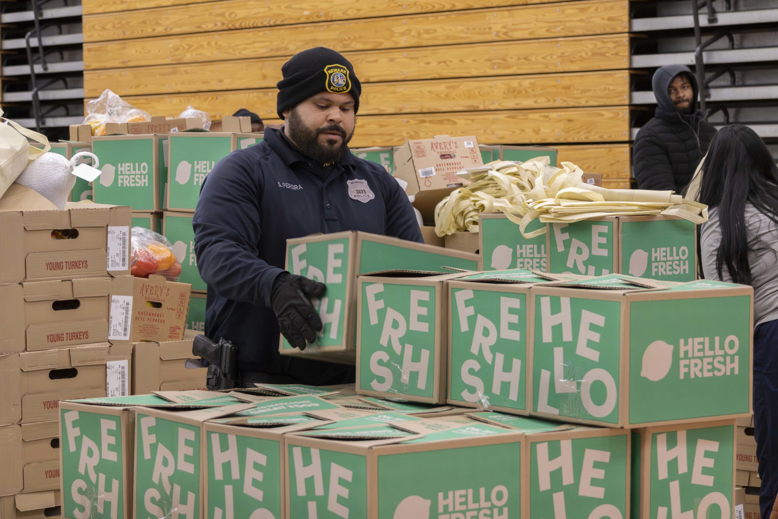 A member of the Newark Police Department assists with loading HelloFresh boxes for local families.